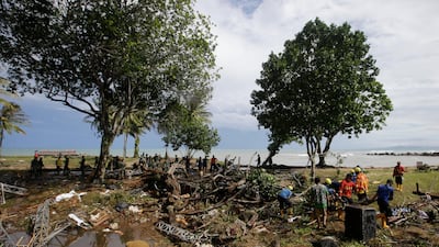 Indonesian soldiers and rescue teams search the bodies of victims at a beach resort in Tanjung Lesung. AP