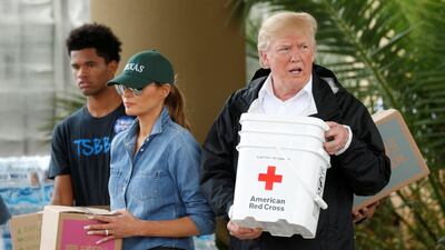 U.S. President Donald Trump and first lady Melania Trump help volunteers deliver supplies to residents at a relief supply drive-thru during a visit with flood survivors and volunteers in the aftermath of Hurricane Harvey in Houston, Texas, U.S., September 2, 2017. REUTERS/Kevin Lamarque