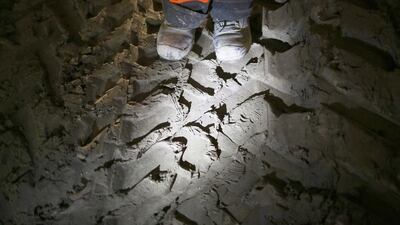 A worker stands on clay dug from a crossrail tunnel marked by machinery tracks and footprints. Peter Macdiarmid / Getty Images