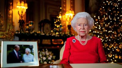 Britain's Queen Elizabeth records her annual Christmas broadcast in Windsor Castle, next to a photograph of her with her late husband, the Duke of Edinburgh. Reuters