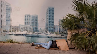 A displaced man sleeps on a street next to a billboard showing Beirut's Marina. The Middle East war has displaced upwards of one million people in Lebanon. AFP