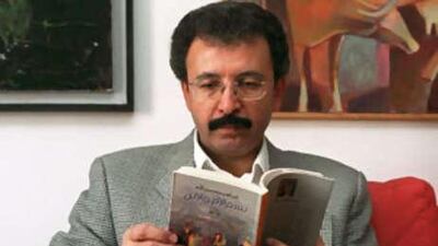 The poet Ibrahim Nasrallah holds his book In the Name of the Mother and the Son in Amman, Jordan, in this 2001 photo. His book Time of White Horses has been selected for the longlist of the Arab Booker prize.