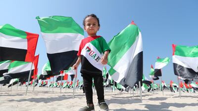 A child wears a T-shirt printed with an UAE sign at Kite beach which is decorated by UAE flag in Dubai. EPA