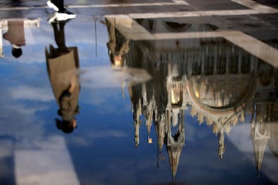 A tourist is reflected in a puddle along with St Mark cathedral, as water starts rising again in Venice. AP Photo