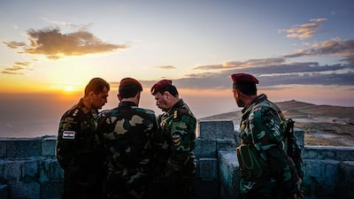 Peshmerga fighters discuss plans at an outpost in the Qara Chokh mountains in northern Iraq. Jack Moore / The National