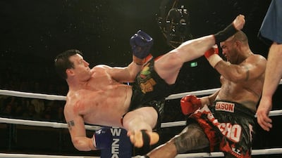 Peter Graham of Australia attacks Jason Suttie of Auckland with a rolling dragon kick in the final at the K1 Kings of Oceania Championship at ASB Stadium, Auckland, New Zealand. 16th July 2004. Peter Graham won the fight, defending his title. Sandra Teddy / Getty Images