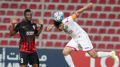 Lokomotiv's Islom Tukhtakhodjaev, right, heads the ball in front of Al Ahli's Asamoah Gyan during the Asian Champions League game at the Rashid Stadium in Dubai on May 9, 2017. Karim Sahib / AFP