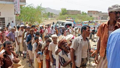 Displaced Yemenis from Hiran, in the border area with Saudi Arabia, receive food aid from Red Crescent operatives in the northern district of Abs in Hajjah province. AFP