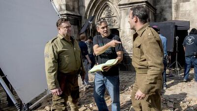 John Goodman, left, the actor and director George Clooney and Jean Dujardin, right, on the set of The Monuments Men. Courtesy Claudette Barius / AP Photo/ Columbia Pictures