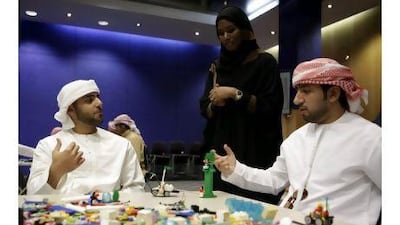 Tarifa Ajaif supervises Ahmed al Marzouqi, 21, left, and Ahmad al Kendi, 25, during the Lego Serious Play workshop.