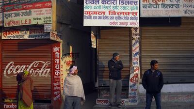 Nepalese stand in front of a closed shops as they look towards protesters (unseen) during the general strike independently called by the Unified Communist Party of Nepal (Maoist) and led by 30 party alliance and the Communist Party of Nepal (Maoist), demanding that the drafting of the new constitution is done on time through consensus, in Kathmandu. Navesh Chitrakar / Reuters
