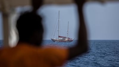 A migrant standing on the deck of the NGO Proactiva Open Arms boat looks at the Open Arms Astral sailboat on July 2, 2018. A Spanish NGO said on June 30, 2018 it had rescued 59 migrants as they tried to cross the Mediterranean from Libya and would dock in Barcelona in Spain after Italy and Malta refused access. Olmo Calvo / AFP