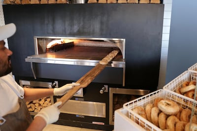 Putting bagels in the on-site wood-fired oven at Bagel Yard