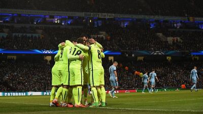Barcelona players huddle to celebrate their second goal scored by Luis Suarez against Manchester City in the Champions League on Tuesday night at the Etihad Stadium. Paul Ellis / AFP