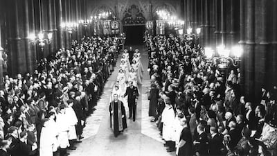 Queen Elizabeth II, then Princess Elizabeth, walks up the aisle of Westminster Abbey with her father King George VI to marry Prince Philip in November 1947