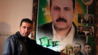 Fayek Al Mabhouh in front of his brother's poster at the family house in northern Gaza Strip's Jabaliya refugee camp.
