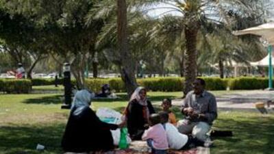 Family and friends picnic together in Apple Garden park off Airport Road in Abu Dhabi.