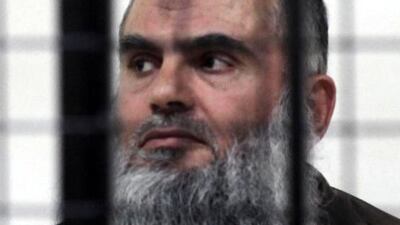 Cleric Abu Qatada looks on from behind the bars at the state security court in Amman during a hearing in his case on June 26, 2014. The court acquitted the cleric, who was deported from Britain last July after a 10-year legal battle, of charges of conspiring to commit acts of terrorism. AFP Photo