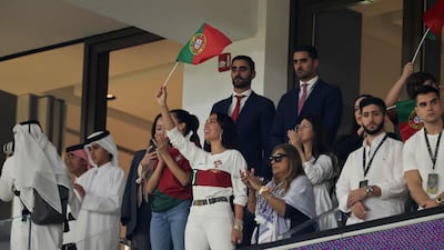 Portugal's forward #07 Cristiano Ronaldo's partner Georgina Rodriguez (C) waves a Portugal flag before the start of the Qatar 2022 World Cup quarter-final football match between Morocco and Portugal at the Al-Thumama Stadium in Doha on December 10, 2022. (Photo by KARIM JAAFAR / AFP)