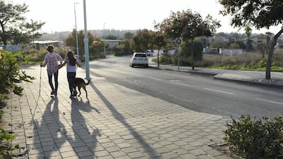 Roni Weingarten and her daughter Rotem, 10, walk their dog in Oranit settlement. Rosie Scammell for The National