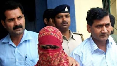 Indian police officials escort a 19-year-old man from a court appearance in Lakhisarai District.