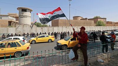 A protester with an Iraqi flag as security forces stand guard outside the Turkish visa office in Baghdad during a demonstration against an attack on the country's autonomous Kurdistan region, which is being blamed on Turkey. AFP