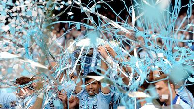 Manchester City’s Sergio Aguero, centre, lifts the English Premier League trophy after his team beat West Ham United on Sunday night at Etihad Stadium. It was the second league title in three years for Manchester City. Andy Rain / EPA