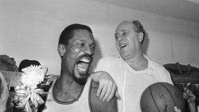Boston Celtics' Bill Russell, left, holds a corsage sent to the dressing room as he celebrates with Celtics coach Red Auerbach after defeating the Los Angeles Lakers to win their eighth-straight NBA Championship. AP