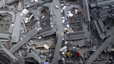 Palestinians collect religious books in the rubble of the Al-Qassam mosque in the Gaza Strip after an Israeli air strike. Heidi Levine / The National