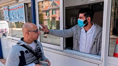 A Cypriot medic checks the temperature of a man crossing the Ledra Palace checkpoint in Nicosia. AFP