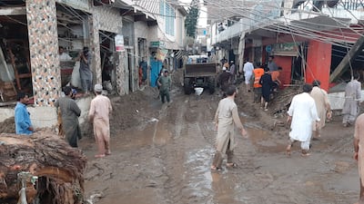 People survey damage caused by the flash floods. EPA