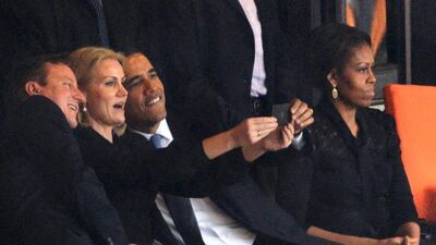 US President Barack Obama (right) and British Prime Minister David Cameron pose for a selfie with Denmark's Prime Minister Helle Thorning Schmidt (centre) as US First Lady Michelle Obama follows late South African president Nelson Mandela’s memorial service. Roberto Schmidt / AFP