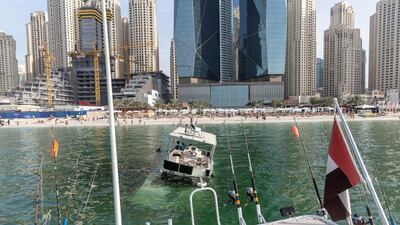 A sunken yacht being salvaged by its owner, Mohamed Irfan, and some volunteer divers off the beach on JBR. Antonie Robertson/The National