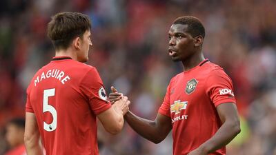 Manchester United's English defender Harry Maguire (L) shakes hands with Manchester United's French midfielder Paul Pogba (R) on the pitch at the final whistle in the English Premier League football match between Manchester United and Chelsea at Old Trafford in Manchester, north west England, on August 11, 2019. Manchester United won the game 4-0. - RESTRICTED TO EDITORIAL USE. No use with unauthorized audio, video, data, fixture lists, club/league logos or 'live' services. Online in-match use limited to 120 images. An additional 40 images may be used in extra time. No video emulation. Social media in-match use limited to 120 images. An additional 40 images may be used in extra time. No use in betting publications, games or single club/league/player publications. / AFP / Oli SCARFF / RESTRICTED TO EDITORIAL USE. No use with unauthorized audio, video, data, fixture lists, club/league logos or 'live' services. Online in-match use limited to 120 images. An additional 40 images may be used in extra time. No video emulation. Social media in-match use limited to 120 images. An additional 40 images may be used in extra time. No use in betting publications, games or single club/league/player publications.