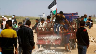 Palestinians pick up stones during a protest at the border fence with Israel, east of Jabalia in the central Gaza city. Mohammed Abed / AFP Photo