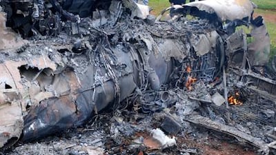 People gather around the smouldering remains of an aircraft after it crashed north of Benghazi yesterday. Witnesses said the aircraft was piloted by anti-Qaddafi rebels and crashed for mechanical reasons.