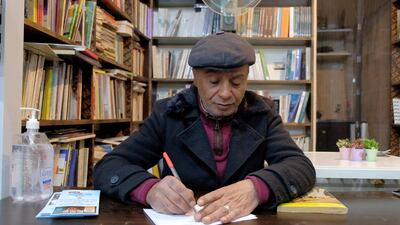 Hussein Yassin, owner of Azbekeye bookshop, holds a copy of his own book. Amy McConaghy / The National