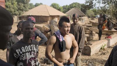 A Chinese businessman with workers while loading timber onto containers in Sintchan Companhe, Guinea. Joe Penney / Reuters