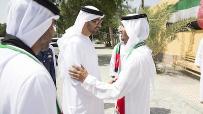 Sheikh Mohammed bin Zayed, Crown Prince of Abu Dhabi Deputy Supreme Commander of the Armed Forces, greets the son of Amna Salem Hamdan Al Marashda (not shown), whilst visiting her home in Kalba.