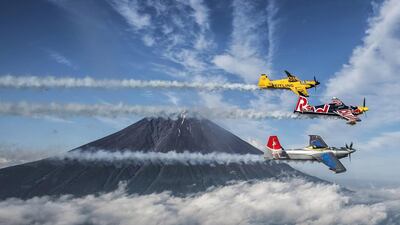 Martin Sonka of the Czech Republic (dark blue plane) leads Nigel Lamb of Great Britain (yellow) and Yoshihide Muroya of Japan (silver) around Mount Fuji before to the third stage of the Red Bull Air Race. Predrag Vuckovic / Red Bull / AFP Photo