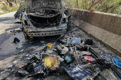 Equipment used by three journalists who were killed in an Israeli strike on Saturday lies next to their destroyed vehicle on a road leading to Jezzine in southern Lebanon. AFP