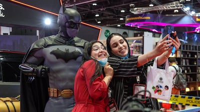 Women take a selfie with the Batman statue.