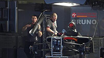 Mechanics in the HRT garage fine-tune Bruno Senna's car in preparation for Sunday's race.