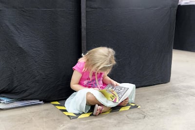 A young child enjoys some quiet time with a good book. Reem Mohammed/The National