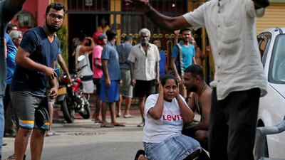 People take shelter as the military try to defuse a suspected van before in Colombo, Sri Lanka. Dinuka Liyanawatte / Reuters