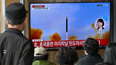 People watch a news broadcast with file footage of a North Korean missile test, at a railway station in Seoul on October 28, 2022. North Korea fired two short-range ballistic missiles, according to South Korea's military. AFP