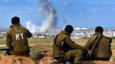 Israeli soldiers watch an air strike on the northern Gaza Strip town of Beit Hanoun.
