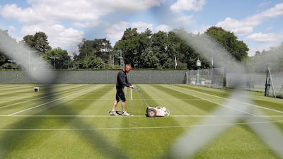 Head groundsman Paul Bishop cuts the grass on the courts at St George’s Hill Lawn Tennis Club in Weybridge as they prepare to reopen, following an easing of restrictions in the UK after the outbreak of the coronavirus. Reuters