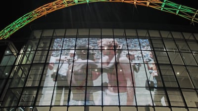 Wembley Stadium's arch is lit up in the colours of Brazil and displays the famous photo of Pele with Bobby Moore. PA