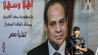 A Palestinian security guard stands on duty next to a giant banner bearing the image of Egyptian President Abdel Fateh El Sisi, hung on the Palestinian government headquarters in Gaza City. Mohammed Abed / AFP Photo